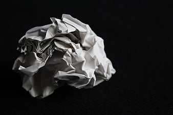 Crumpled white paper ball on black background