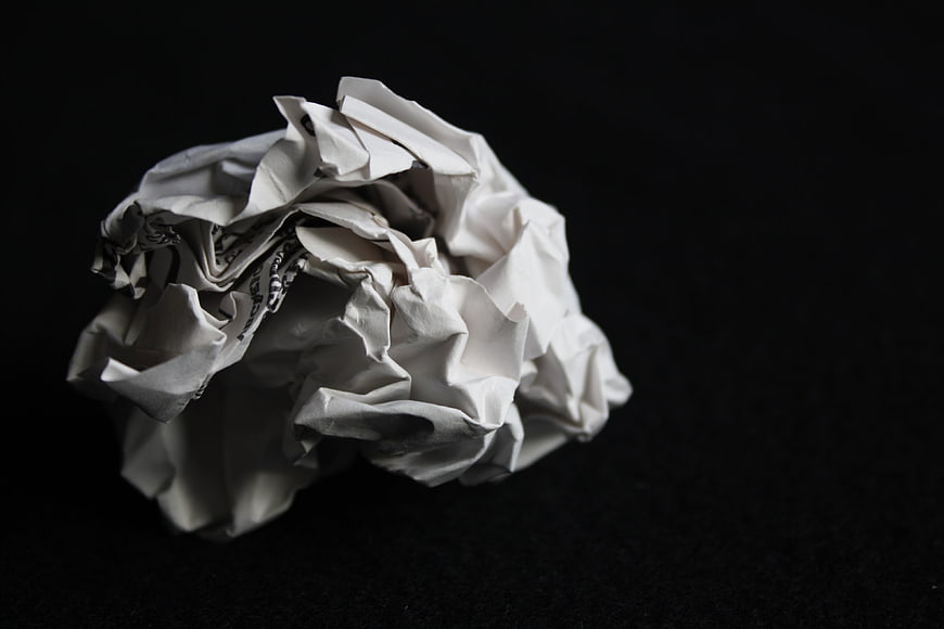 Crumpled white paper ball on black background