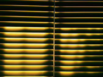 Abstract yellow light patterns through window blinds