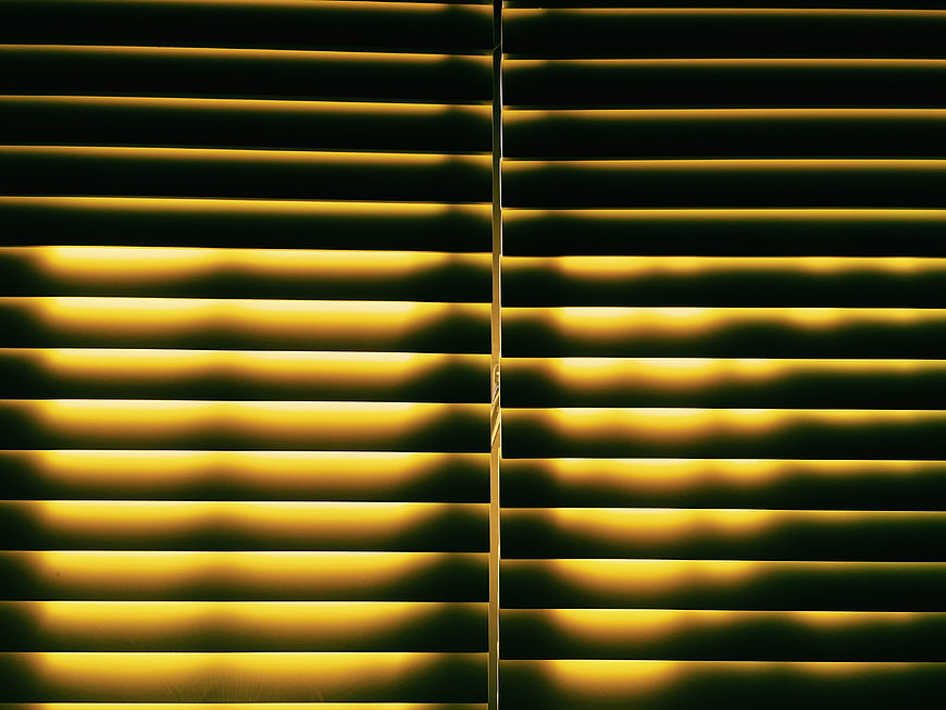 Abstract yellow light patterns through window blinds