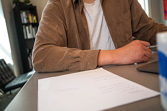 Man Signing Documents at Desk with Pen