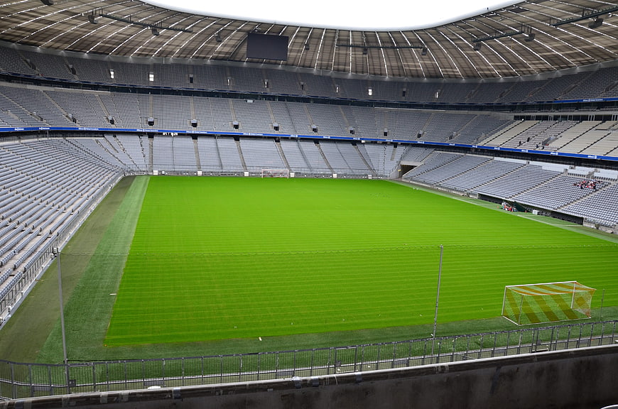Empty Soccer Stadium with Green Pitch and Gray Seats