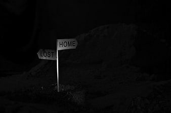 Dark signpost pointing to home and lost at night
