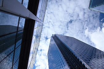 Low angle view of modern glass skyscrapers against blue sky