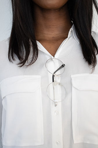 Close-up of woman wearing white shirt with glasses tucked in collar