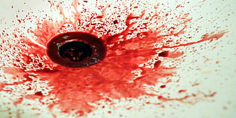 Red liquid splatter in white sink drain