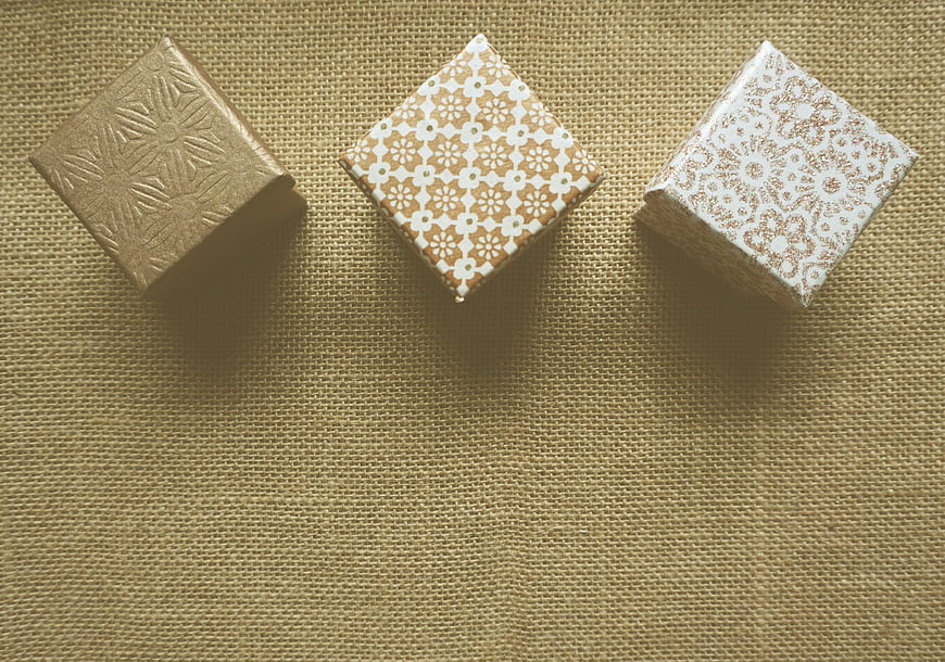 Three decorative gift boxes on burlap background