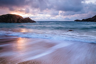 Dramatic Sunset Long Exposure Coastal Beach with Rocky Cliffs