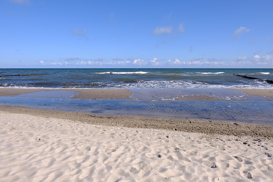 Sandy beach with gentle waves and blue sky