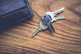 House keys and wallet on rustic wooden table