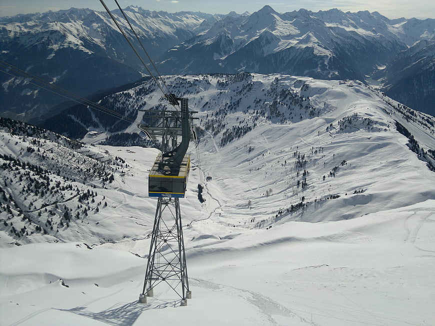 Gondola lift tower in snowy alpine ski resort landscape