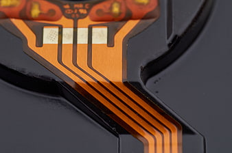 Macro shot of orange flexible circuit board ribbon cable