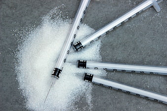 Insulin syringes on pile of white sugar crystals
