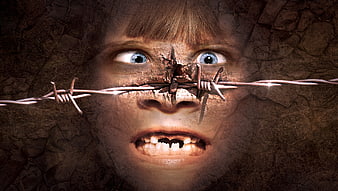 Surreal composite of child's face with barbed wire and cracked texture
