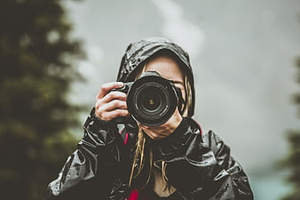 Woman Photographer in Rain Jacket Taking Photo