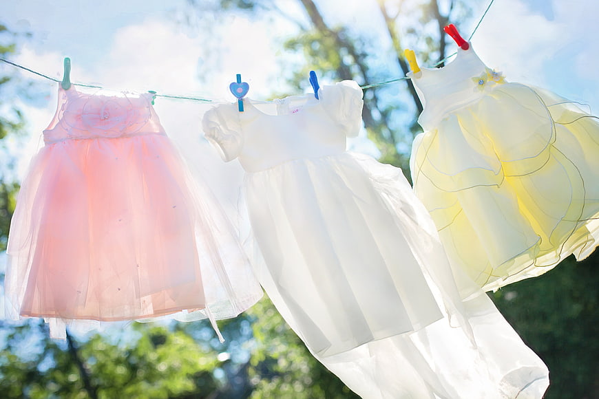 Pastel Children's Dresses Hanging on Clothesline in Sunlight