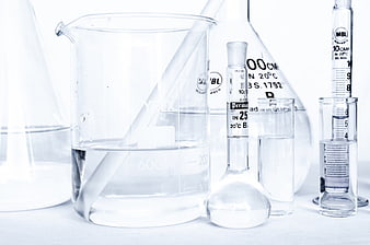 Laboratory glassware with clear liquid on white background