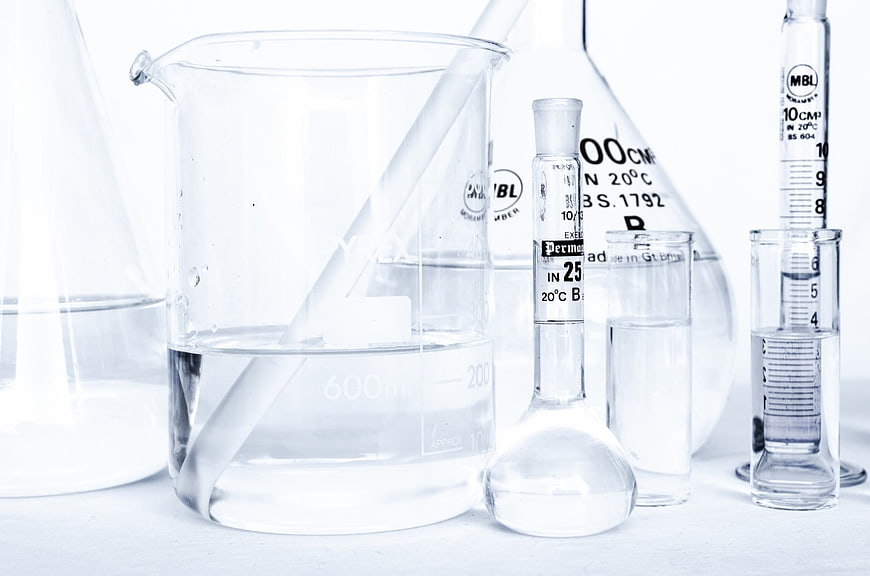 Laboratory glassware with clear liquid on white background