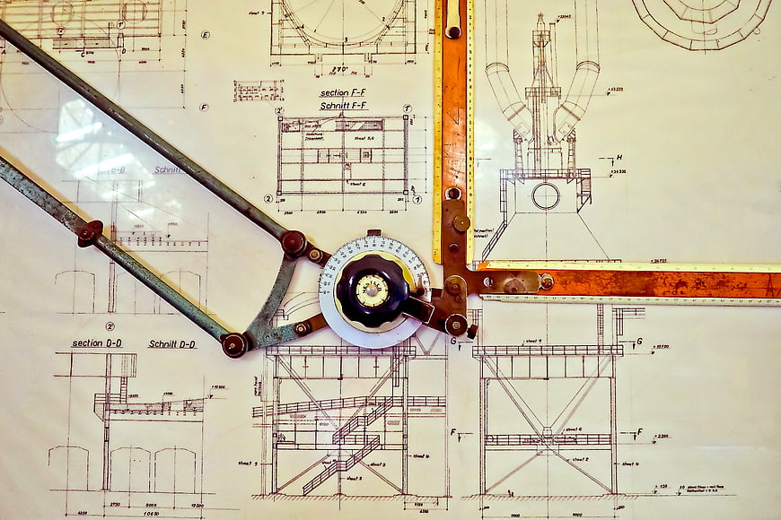 Vintage drafting tools on architectural blueprint