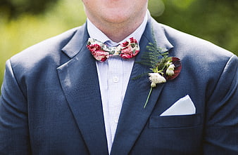 Groom in Blue Suit with Floral Bow Tie and Boutonniere