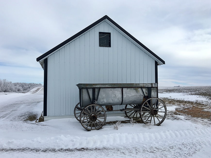 White Barn with Vintage Wagon in Snowy Winter Landscape