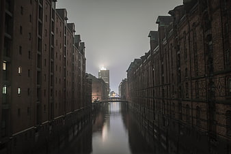 Atmospheric canal view between historic brick warehouse buildings
