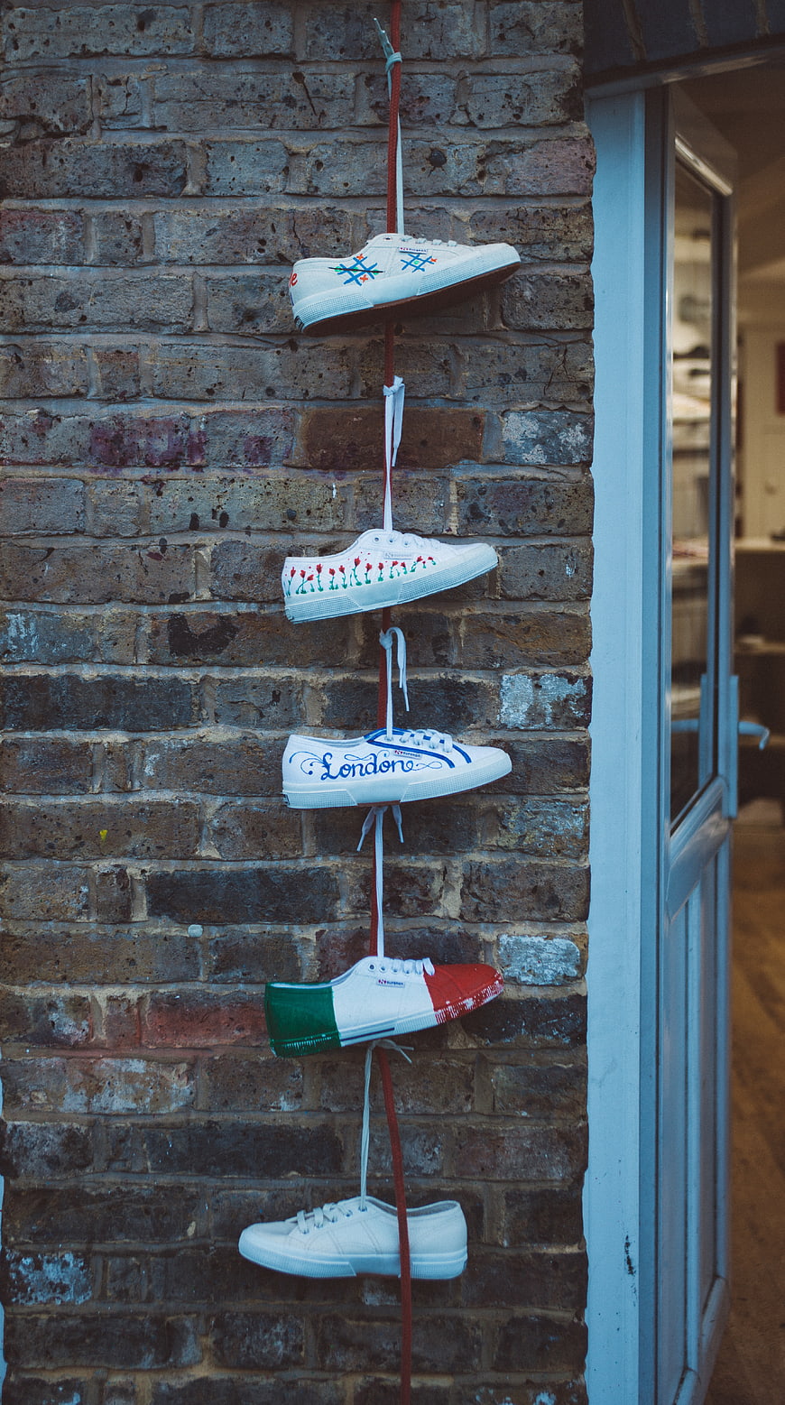 Custom Painted Sneakers Hanging on Brick Wall