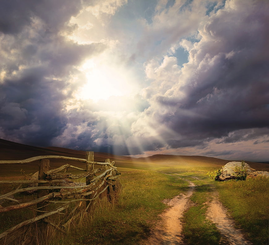 Dramatic Landscape with Sun Rays Breaking Through Storm Clouds