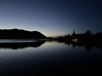 Serene Lake Landscape at Dusk with Church Silhouette and Reflections
