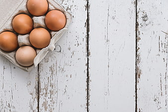 Brown Eggs in Cardboard Tray on Rustic White Wooden Table