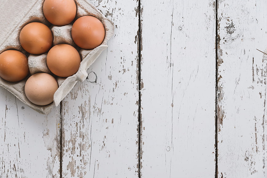 Brown Eggs in Cardboard Tray on Rustic White Wooden Table