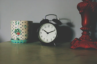 Vintage Alarm Clock and Floral Mug on Wooden Table