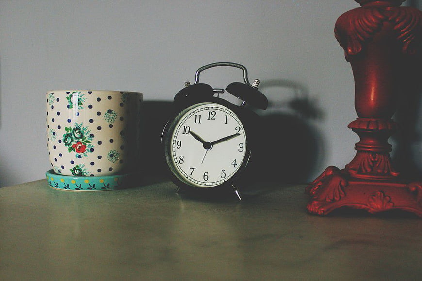 Vintage Alarm Clock and Floral Mug on Wooden Table