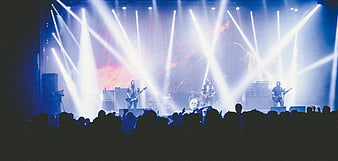 Rock band performing on stage with dramatic blue lighting