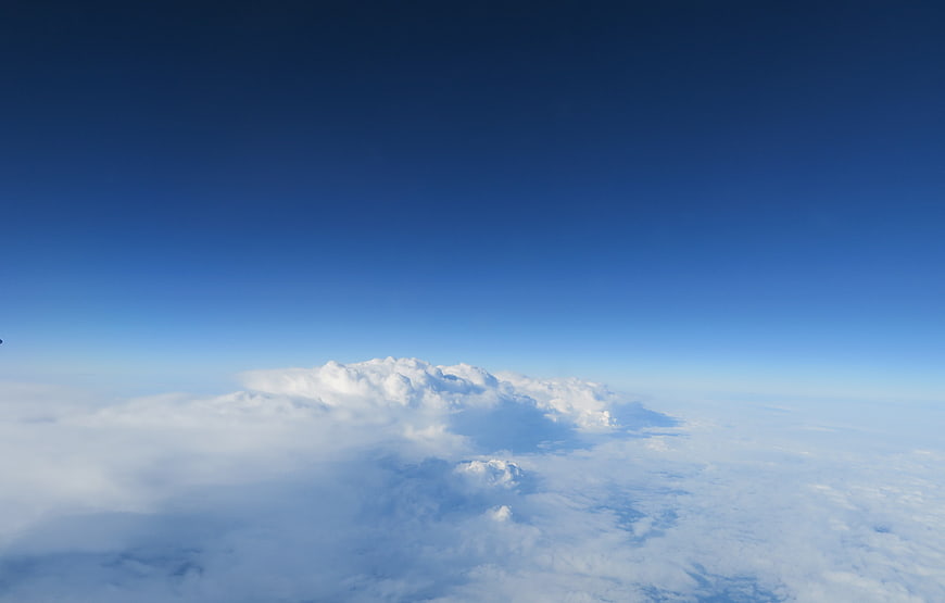 Aerial View of Fluffy White Clouds Against Deep Blue Sky