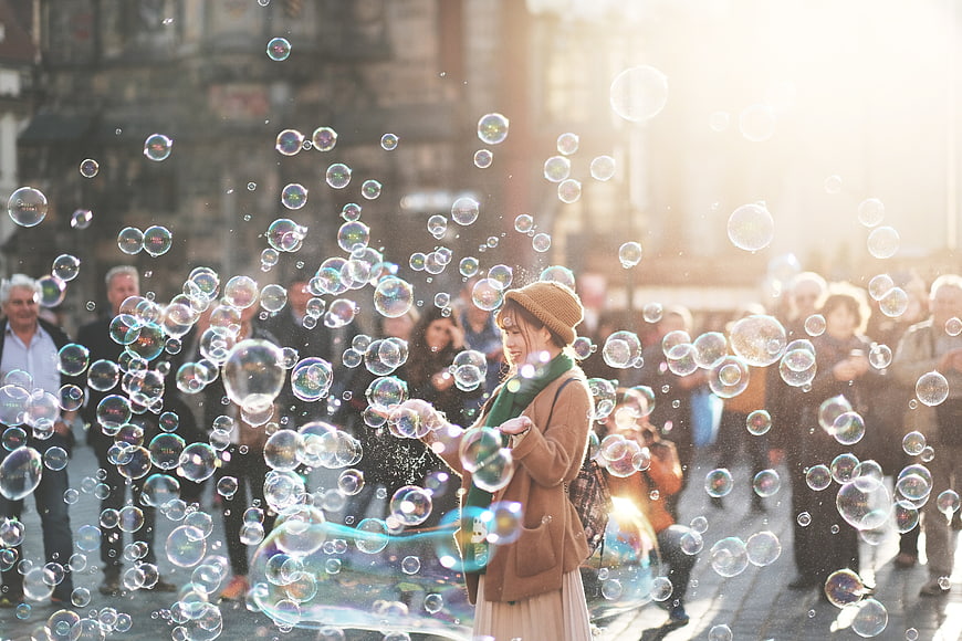Woman Making Bubbles in Crowded Street