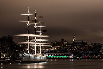 Illuminated Tall Ship Docked in Stockholm Harbor at Night