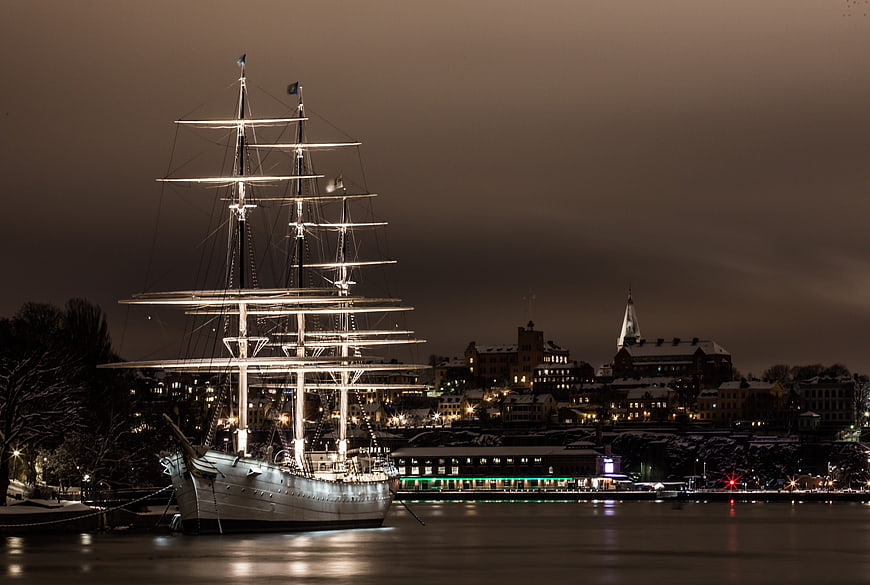Illuminated Tall Ship Docked in Stockholm Harbor at Night