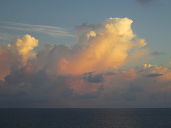 Dramatic sunset clouds over calm ocean horizon