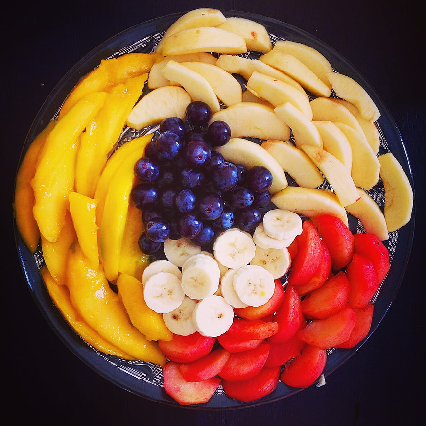 Colorful fruit platter with mango, grapes, and bananas