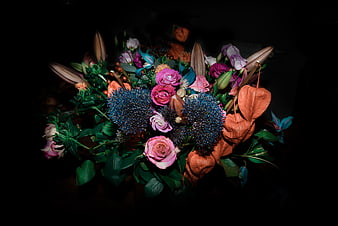 Dark moody floral bouquet with blue thistles and pink roses