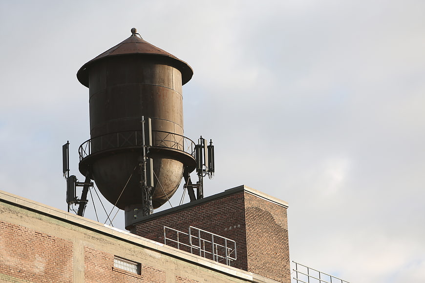 Rusty rooftop water tower on brick building