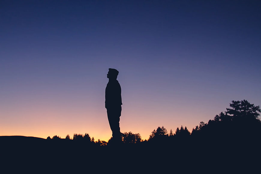 Silhouette of Man Standing Against Sunset Sky