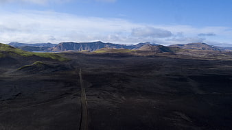 Aerial View of Volcanic Landscape with Dirt Road and Mountains