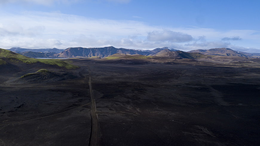 Aerial View of Volcanic Landscape with Dirt Road and Mountains