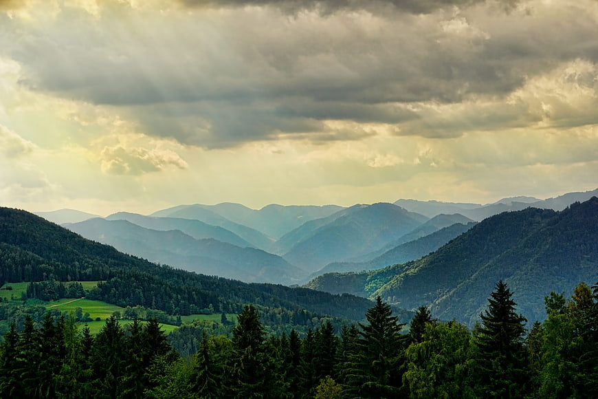 Dramatic Mountain Landscape With Sunbeams And Forested Hills