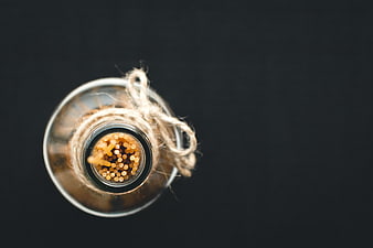 Top view of spaghetti in glass bottle on black background