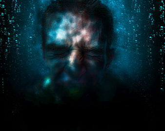 Man's face submerged underwater with raindrops and blue light