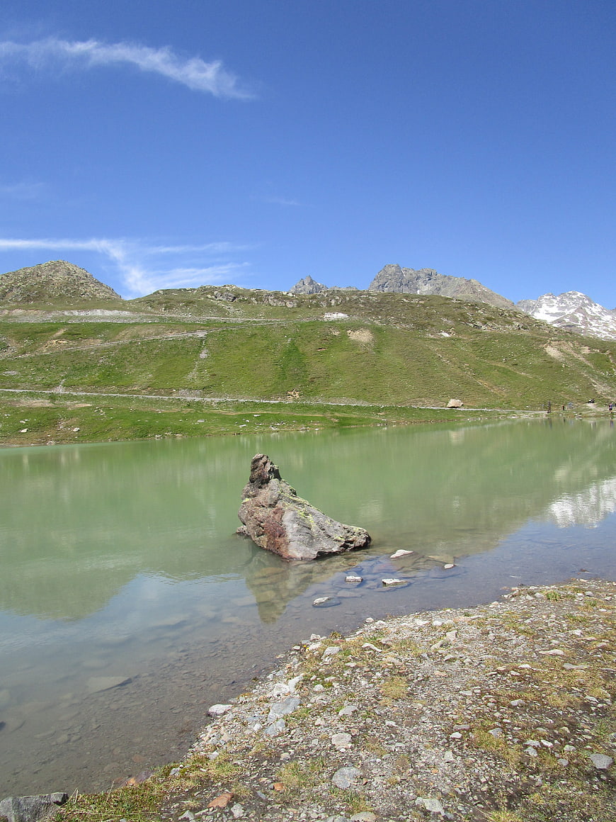 Alpine lake with rock formation and mountain reflection
