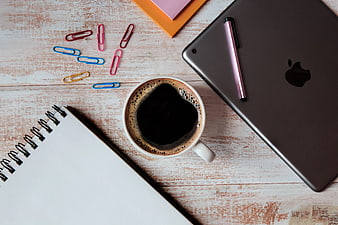 Flat lay workspace with coffee, tablet, and notebook